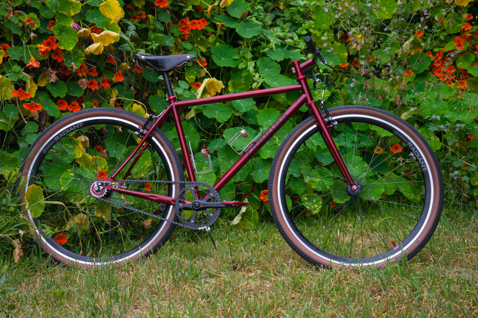 Oxblood red single-speed bike in front of nasturtiums
