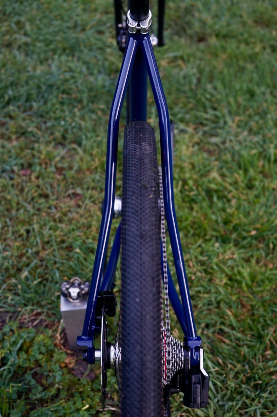 Navy seat stays wrapping around a gravel tire, seen from behind