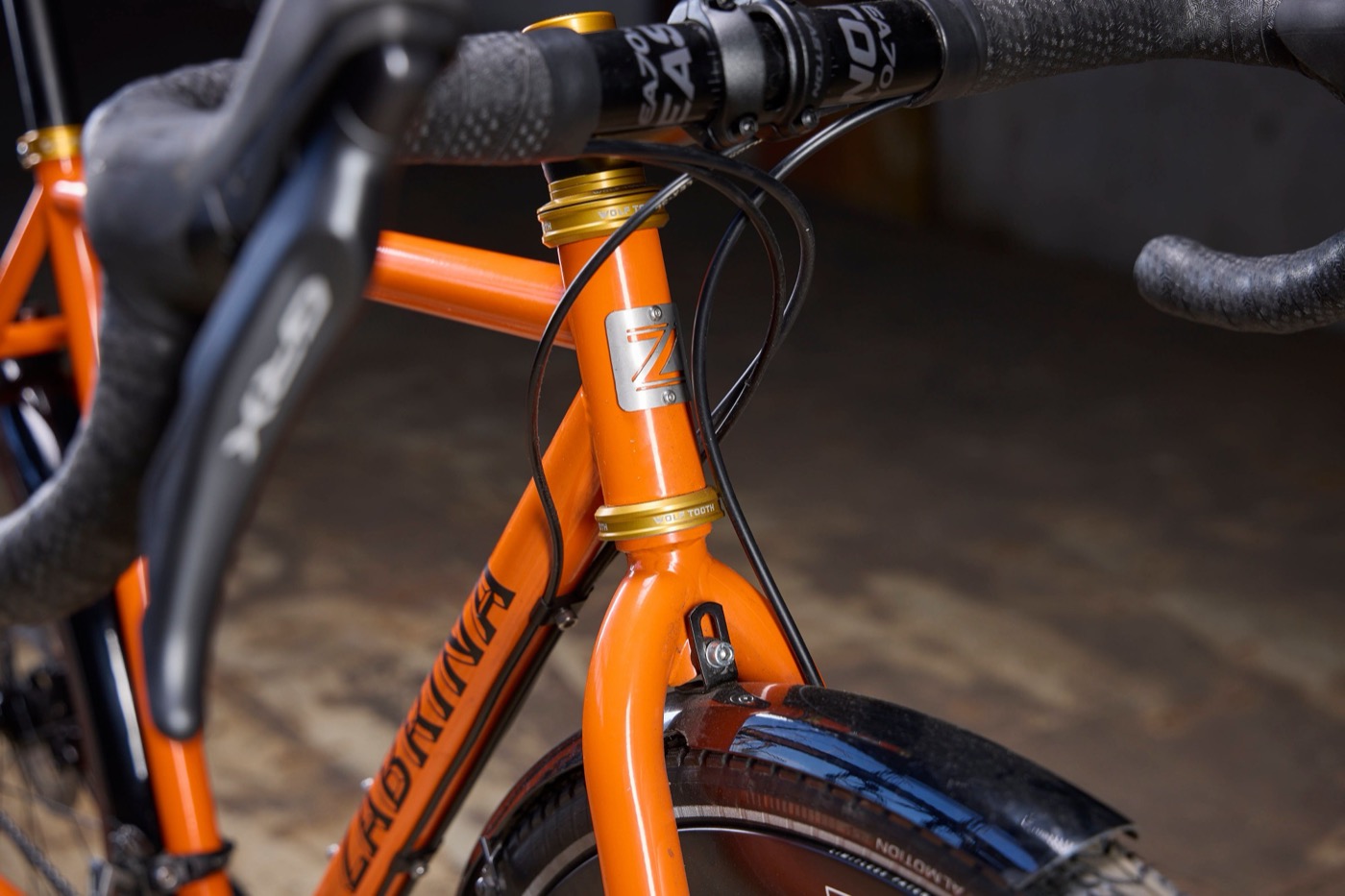 Steel Z head badge on the orange head tube between gold headset cups